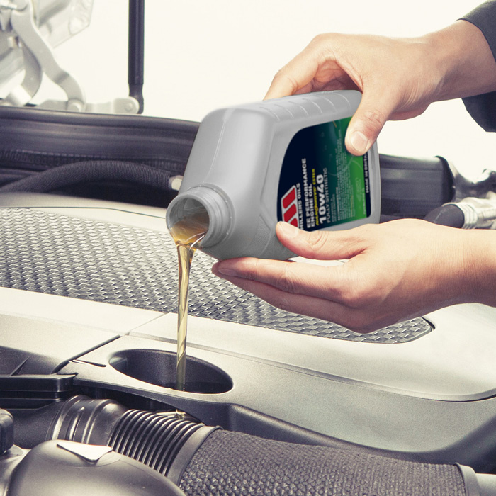 Photo of EE Perfromance being poured into a car engine