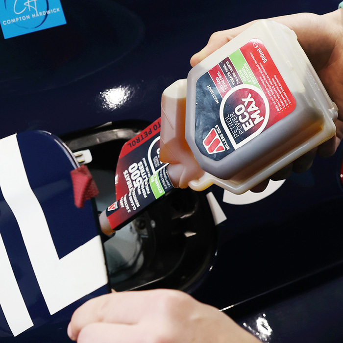 Photo of Petrol Power ECOMAX being poured into a fuel tank on a car