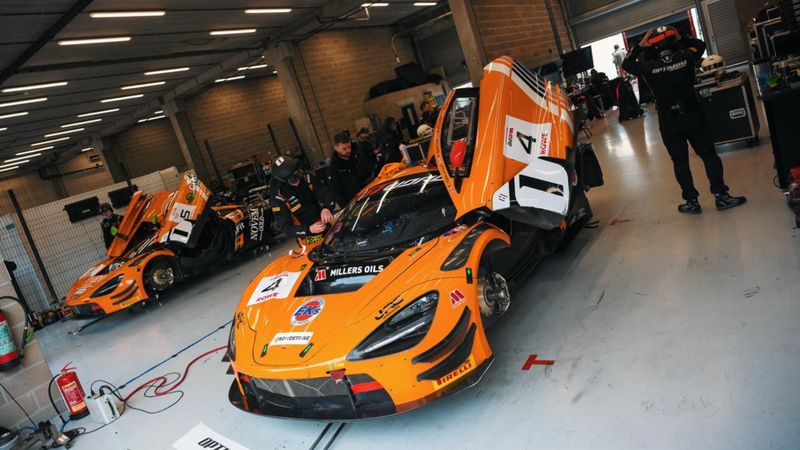 Adam Smalley's Mclaren in the garage with the team working on it