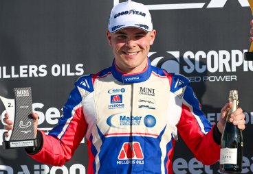 Photo of Harry Hickton at Brands Hatch on the podium, holding his 2nd place trophy and bottle of cava
